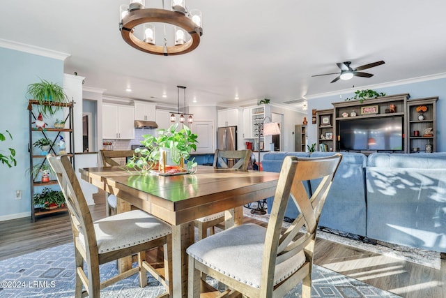 dining room featuring ornamental molding, ceiling fan with notable chandelier, and wood-type flooring