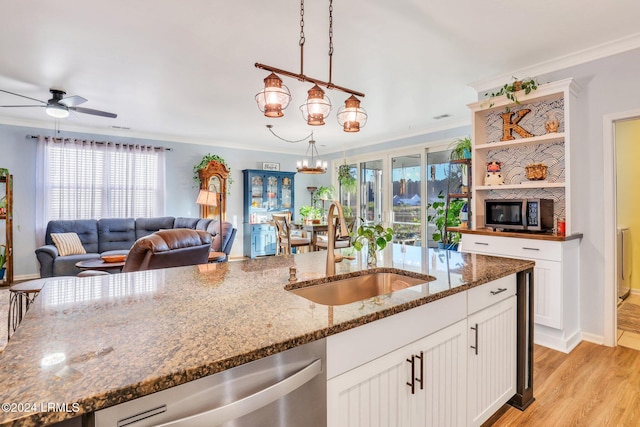 kitchen featuring pendant lighting, sink, appliances with stainless steel finishes, dark stone countertops, and white cabinets