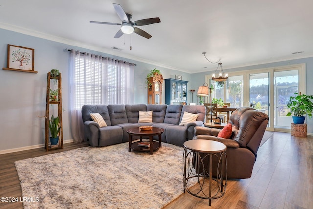 living room featuring ornamental molding, dark wood-type flooring, and ceiling fan with notable chandelier