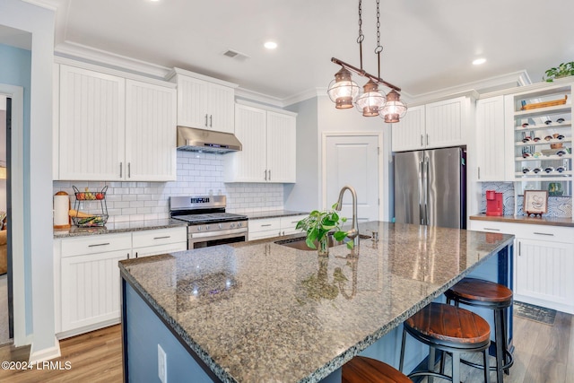 kitchen with white cabinetry, appliances with stainless steel finishes, and an island with sink