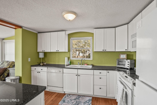 kitchen featuring sink, white appliances, light hardwood / wood-style floors, white cabinets, and a textured ceiling