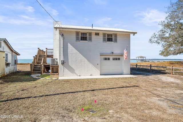 back of house with a garage and a water view