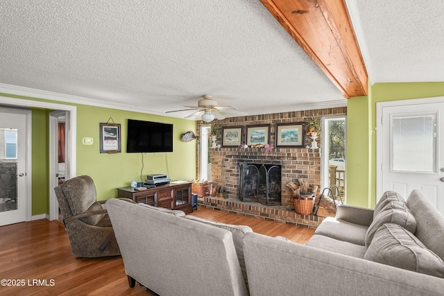 living room with wood-type flooring, ceiling fan, a textured ceiling, and a fireplace