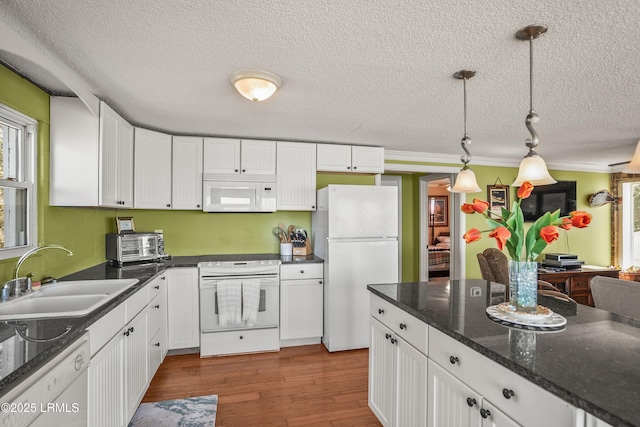 kitchen with white cabinetry, sink, white appliances, and hanging light fixtures