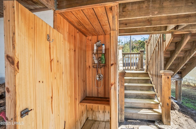 stairway featuring wood walls