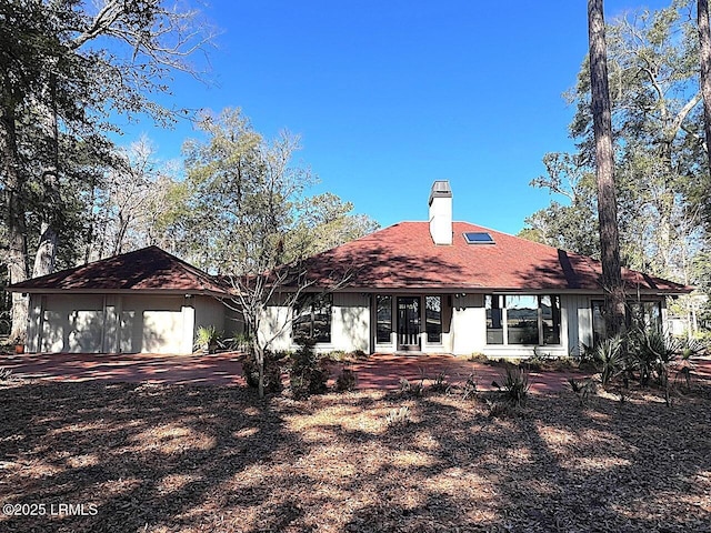 view of front of house with an attached garage and a chimney