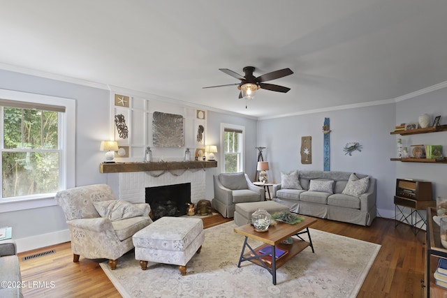 1413 Pigeon Point Rd, Beaufort, SC 29902 - living room with plenty of natural light, wood finished floors, ornamental molding, ceiling fan, and a fireplace