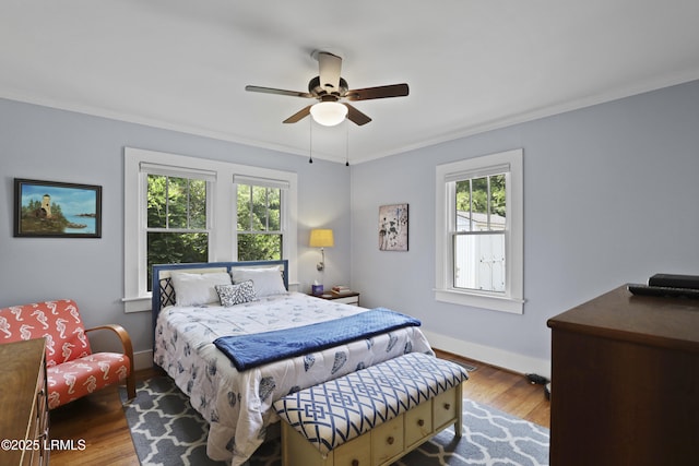 1413 Pigeon Point Rd, Beaufort, SC 29902 - bedroom with multiple windows, wood finished floors, crown molding, baseboards, and a ceiling fan