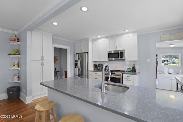 1413 Pigeon Point Rd, Beaufort, SC 29902 - kitchen featuring stainless steel appliances, a sink, crown molding, backsplash, and white cabinets