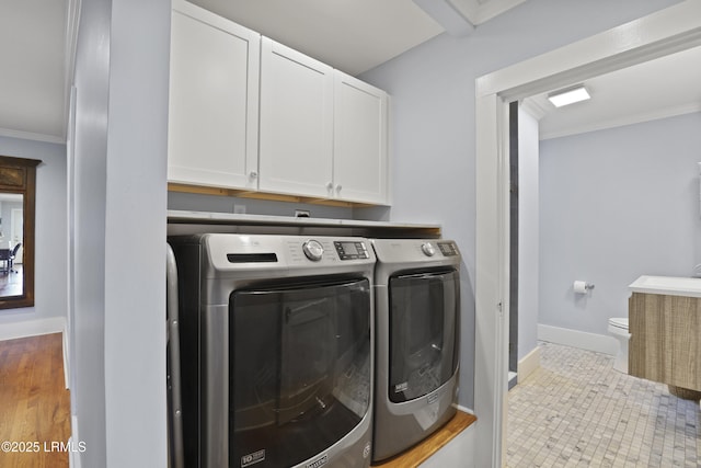 1413 Pigeon Point Rd, Beaufort, SC 29902 - clothes washing area with washing machine and clothes dryer, cabinet space, crown molding, and baseboards