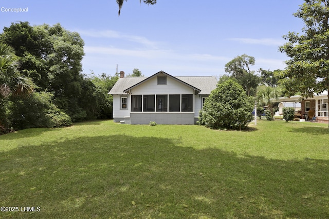 1413 Pigeon Point Rd, Beaufort, SC 29902 - back of house with a yard, a sunroom, roof with shingles, and a chimney