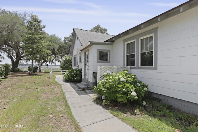 1413 Pigeon Point Rd, Beaufort, SC 29902 - view of home's exterior with roof with shingles and a lawn