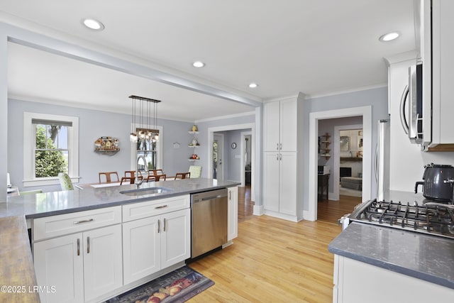 1413 Pigeon Point Rd, Beaufort, SC 29902 - kitchen featuring stainless steel appliances, a sink, white cabinetry, crown molding, and light wood finished floors