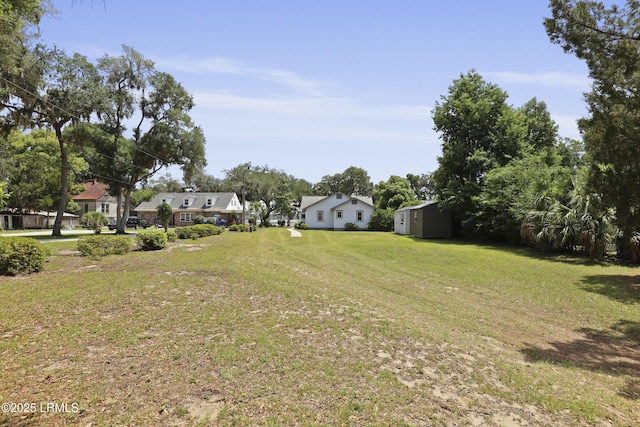 1413 Pigeon Point Rd, Beaufort, SC 29902 - view of grassy yard featuring a storage unit, an outbuilding, and a residential view