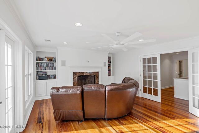 104 Barnaby Blf, Seabrook, SC 29940 - living area with a ceiling fan, built in features, wood finished floors, ornamental molding, and a premium fireplace