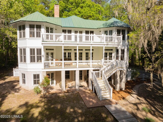 104 Barnaby Blf, Seabrook, SC 29940 - back of house with a balcony, french doors, a chimney, a patio area, and a metal roof