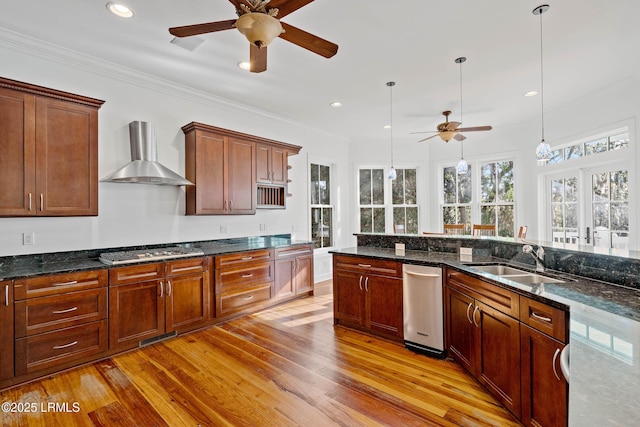 104 Barnaby Blf, Seabrook, SC 29940 - kitchen with a ceiling fan, wall chimney range hood, stainless steel gas cooktop, light wood-style floors, and pendant lighting
