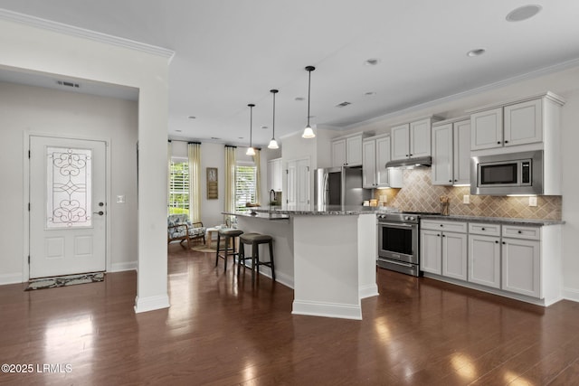 149 Kings Creek Dr, Bluffton, SC 29909 - kitchen with appliances with stainless steel finishes, a kitchen island with sink, dark wood-style floors, tasteful backsplash, and ornamental molding