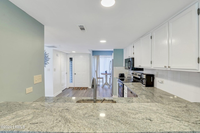 kitchen featuring white cabinetry, sink, stainless steel appliances, and light stone countertops