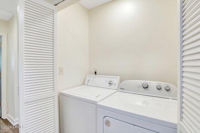 washroom with hardwood / wood-style flooring and washer and dryer