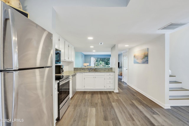 kitchen featuring white cabinetry, appliances with stainless steel finishes, light hardwood / wood-style floors, and sink