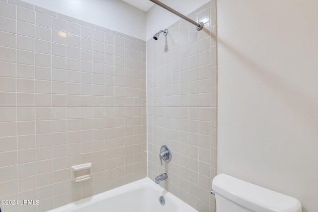 bathroom with toilet and tiled shower / bath combo