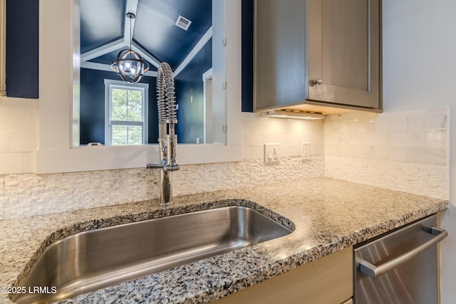 kitchen featuring tasteful backsplash, visible vents, stainless steel dishwasher, a sink, and light stone countertops