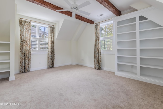 additional living space featuring plenty of natural light, visible vents, beam ceiling, and light colored carpet