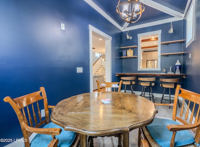 dining room featuring stairs, an inviting chandelier, wood finished floors, and baseboards