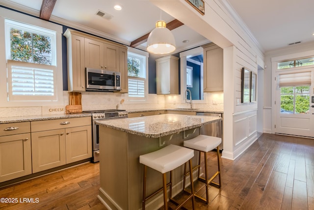 kitchen featuring visible vents, decorative backsplash, decorative light fixtures, stainless steel appliances, and crown molding