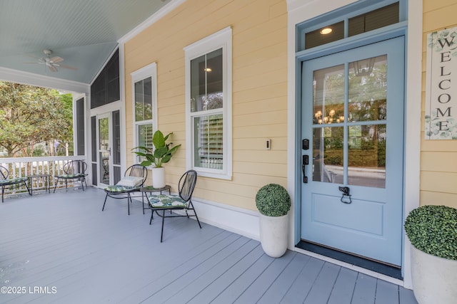 doorway to property featuring covered porch and a ceiling fan