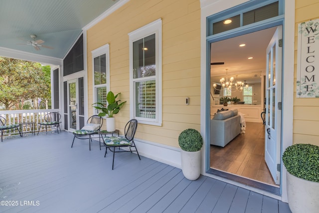 wooden deck with a porch and a ceiling fan