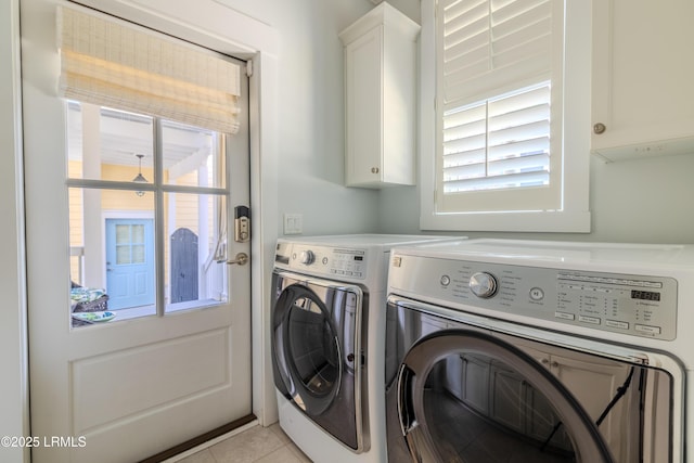 washroom with cabinet space, independent washer and dryer, and light tile patterned floors