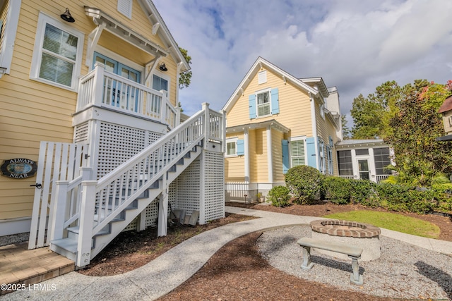 exterior space featuring an outdoor fire pit and stairs