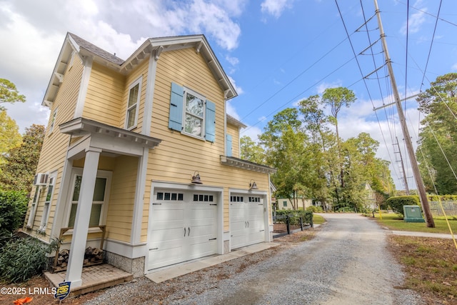 view of property exterior featuring gravel driveway and a garage