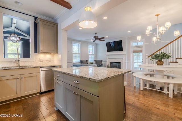 kitchen with light stone counters, gray cabinetry, a center island, dishwasher, and pendant lighting