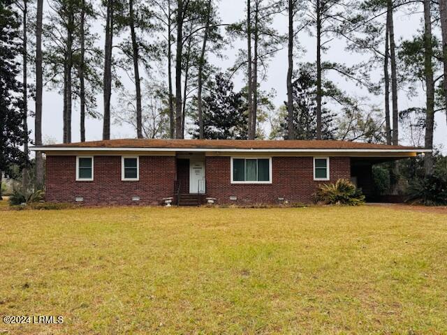 view of front facade with a carport and a front lawn