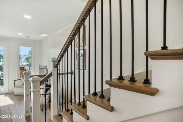 staircase featuring crown molding and wood-type flooring
