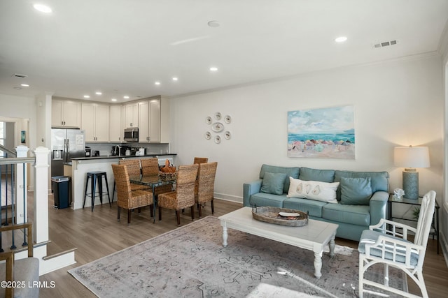 living room with ornamental molding and hardwood / wood-style floors