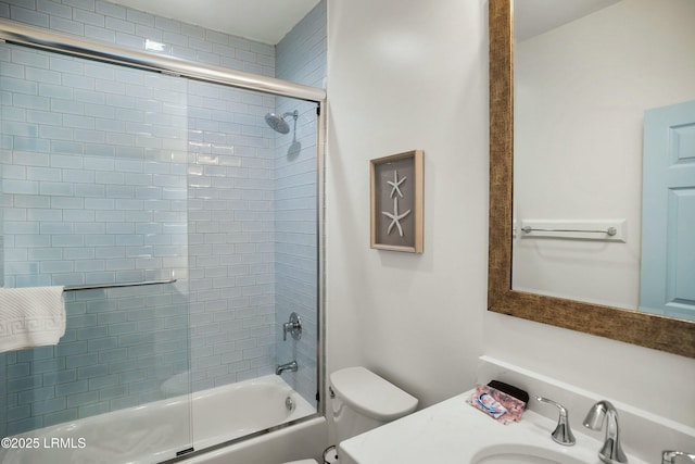full bathroom featuring bath / shower combo with glass door, sink, and toilet