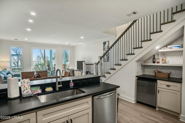 kitchen featuring sink, light hardwood / wood-style flooring, white cabinetry, fridge, and stainless steel dishwasher