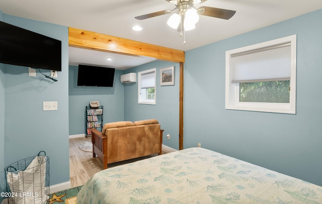 bedroom featuring beam ceiling, light wood-type flooring, a wall mounted air conditioner, and ceiling fan