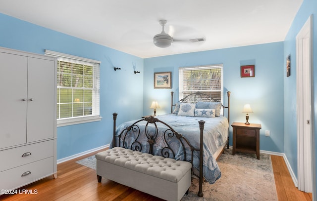 bedroom featuring multiple windows, a closet, ceiling fan, and light hardwood / wood-style flooring