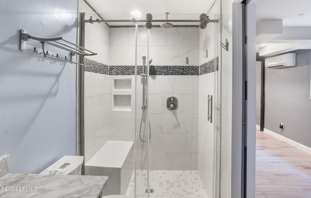 bathroom with hardwood / wood-style flooring, vanity, a wall mounted AC, and walk in shower