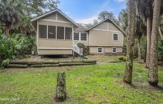 rear view of house with a sunroom and a lawn