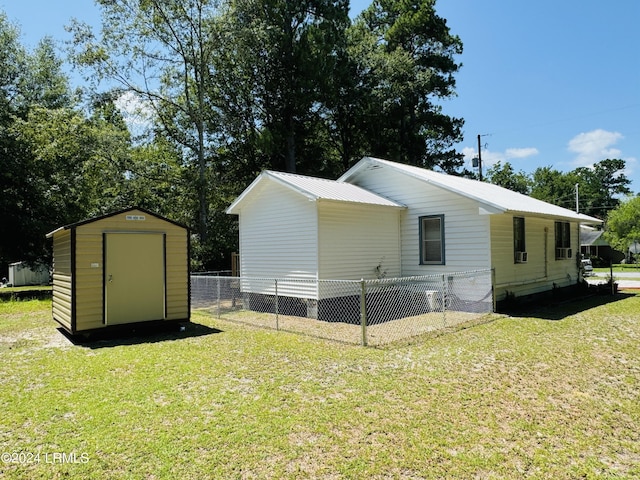 view of home's exterior with a yard and a storage unit