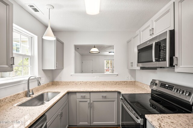120B Tamara Ln, Port Royal, SC 29935 - kitchen with appliances with stainless steel finishes, gray cabinetry, a textured ceiling, hanging light fixtures, and light stone countertops