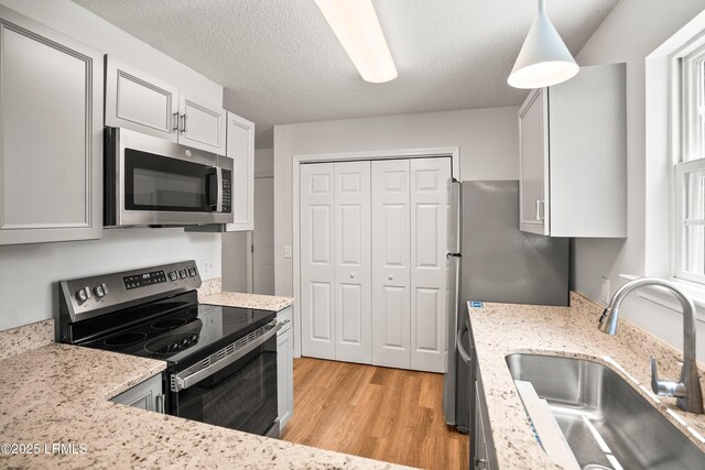 120B Tamara Ln, Port Royal, SC 29935 - kitchen with appliances with stainless steel finishes, light wood finished floors, light stone counters, a textured ceiling, and white cabinetry