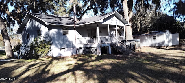 view of side of home featuring a shed and a porch