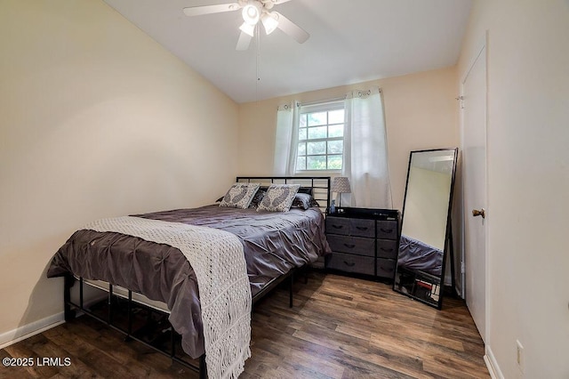 bedroom featuring lofted ceiling, wood finished floors, baseboards, and a ceiling fan
